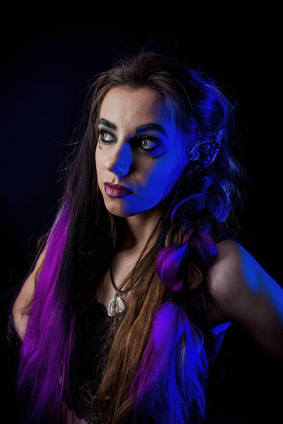 Girl in werewolf style on a black background with blue light. - Foto, immagini
