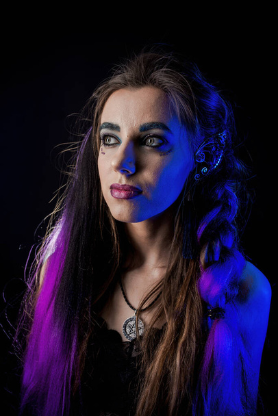 Girl in werewolf style on a black background with blue light. - Foto, Imagen