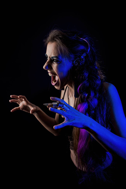 Girl in werewolf style on a black background with blue light - Fotó, kép