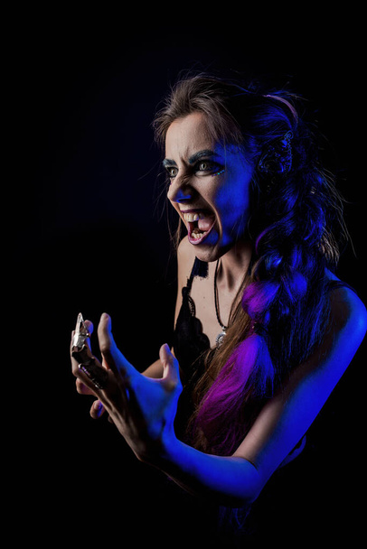 Girl in werewolf style on a black background with blue light - Fotó, kép