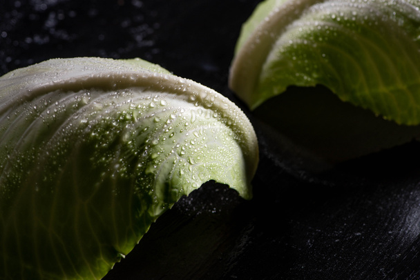 close up view of wet green cabbage leaves on black - Fotoğraf, Görsel