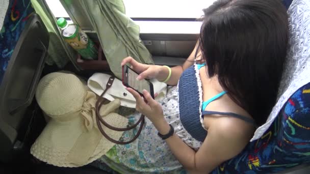 Ázsiai nő használt érintőképernyő Tablet Smartphone Device, Fiatal nő videó megtekintése touchpad, majd válasszon egy másikat a nappali utazás a buszon, 4K -Dan - Felvétel, videó