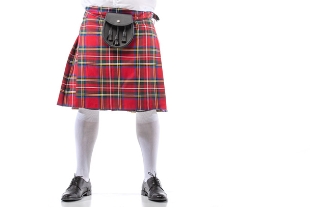 白い背景に革のベルトの袋で赤いキルトでスコットランドの男のクロップドビュー - 写真・画像