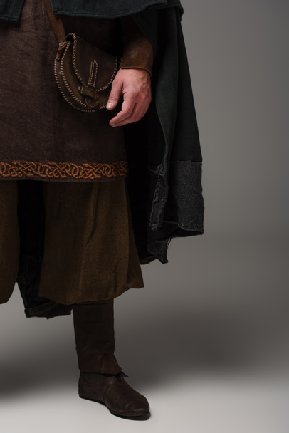 cropped view of medieval Scottish man in mantel on grey background - Zdjęcie, obraz