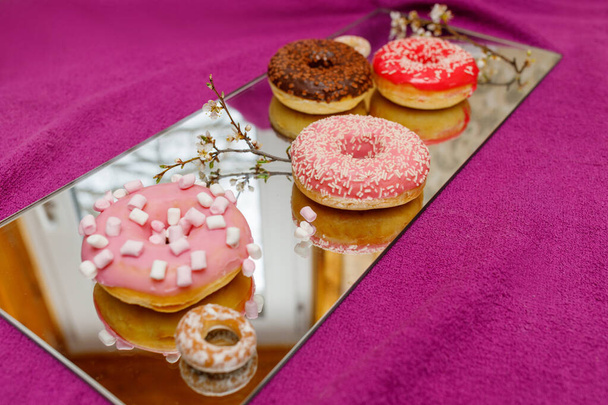 Bunte Donuts auf einer Spiegeloberfläche - Foto, Bild