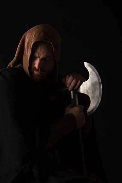 Κατσουφιασμένος μεσαιωνικός Σκωτσέζος πολεμιστής με τσεκούρι μάχης στο τζάκι απομονωμένος στα μαύρα - Φωτογραφία, εικόνα