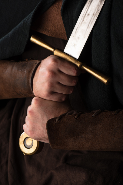 ostříhaný pohled na středověkého skotského válečníka s mečem v rukou - Fotografie, Obrázek