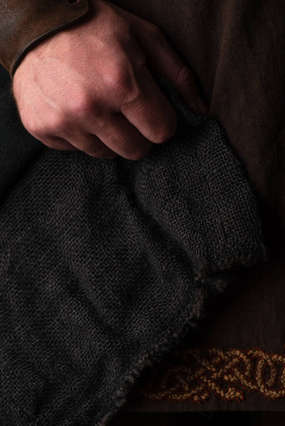 hand of medieval Scottish adult man in brown clothing  - Фото, зображення