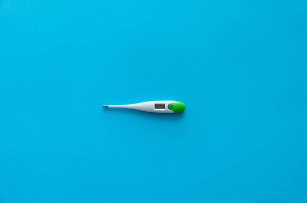 Digital body thermometer lying on a blue background. Medical thermometers. - Foto, immagini