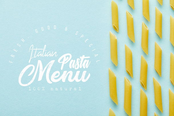 flat lay with raw penne on blue background with Italian pasta menu illustration - Foto, afbeelding