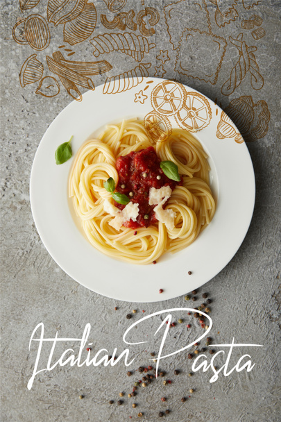 Draufsicht auf köstliche Spaghetti mit Tomatensauce auf Teller auf grauer strukturierter Oberfläche mit italienischer Nudelillustration - Foto, Bild