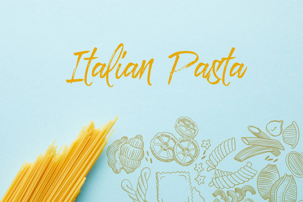 top view of raw spaghetti on blue background with Italian pasta illustration - Foto, Bild