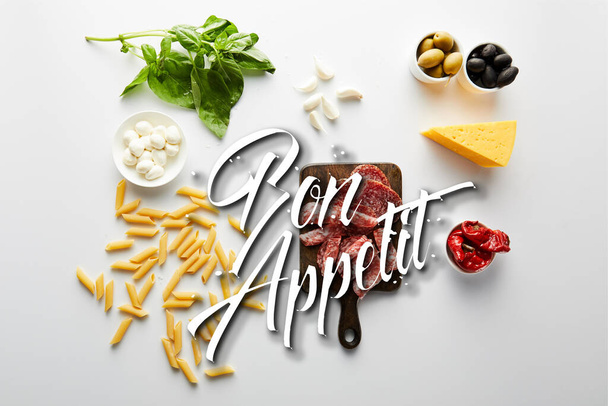 Вид зверху на макаронні вироби, м'ясну тарілку, сир та інгредієнти на білому фоні, ілюстрація апетиту
 - Фото, зображення