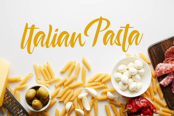 Vista dall'alto penne, piatto di carne, grattugia e ingredienti su fondo bianco, illustrazione pasta italiana
 - Foto, immagini
