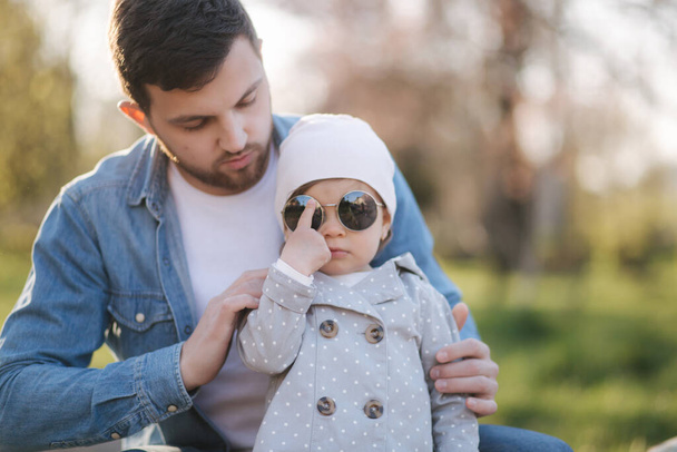 Papa setzt seiner kleinen Tochter Sonnenbrille auf - Foto, Bild