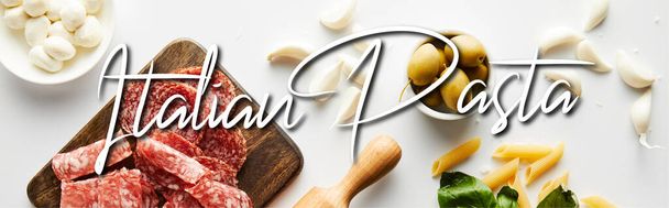 Panoramic orientation of meat platter, rolling pin, pasta, garlic and bowls with olives and mozzarella on white background, italian pasta illustration - Foto, afbeelding
