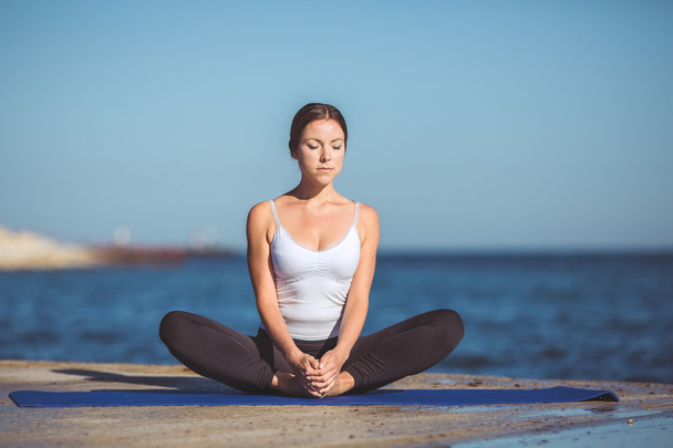 Young woman, sea shore, yoga exercises - Фото, зображення
