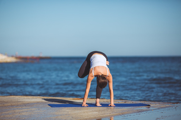 Young woman, sea shore, yoga exercises - Photo, Image