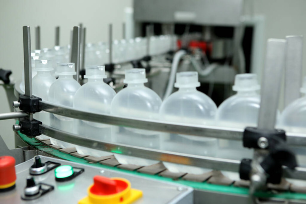 farmaceutische industrie, medicijnen pillen vullen de plastic fles op de productielijn machine transportband in de medische fabriek. Voldoende vul- en afdichtingsmachine, apparatuur in de farmaceutische industrie. - Foto, afbeelding