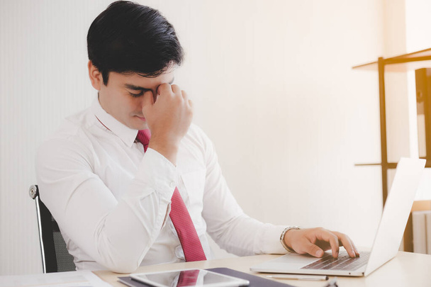 Businessman get stressed from work. He feeling sick, tired of overworked. Exhausted mature guy massaging nose, closed eyes while sit at his work place in office. Businessmen taking a break, eyestrain - Photo, Image