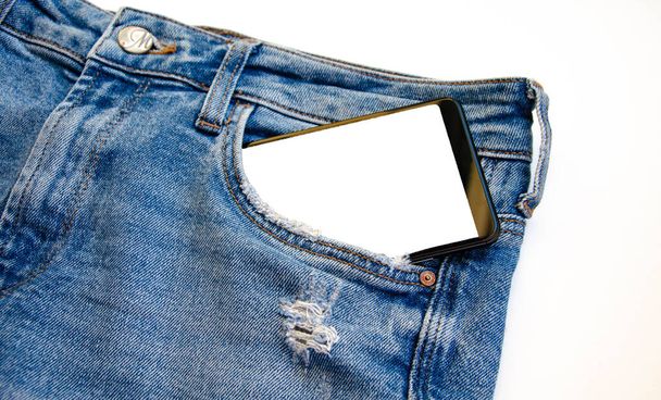 Λευκή οθόνη smartphone στην τσέπη τζιν. Έξυπνο μέρος για κείμενο. Smartphone σε μια τσέπη σε λευκό φόντο. Αντιγραφή χώρου - Φωτογραφία, εικόνα
