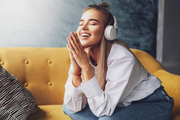 Young female listening to music in headphones. Audio streaming and sharing online in social media, Internet accounts. - Foto, Imagem