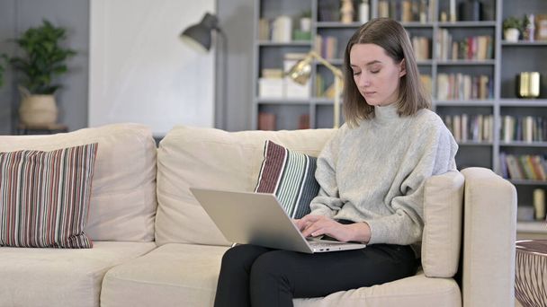 Ambitieuze jonge vrouw werkt op laptop op de bank - Foto, afbeelding