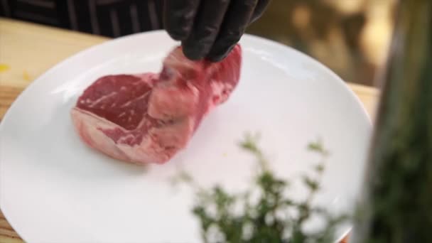 Повар кладет сырое мясо на тарелки
 - Кадры, видео
