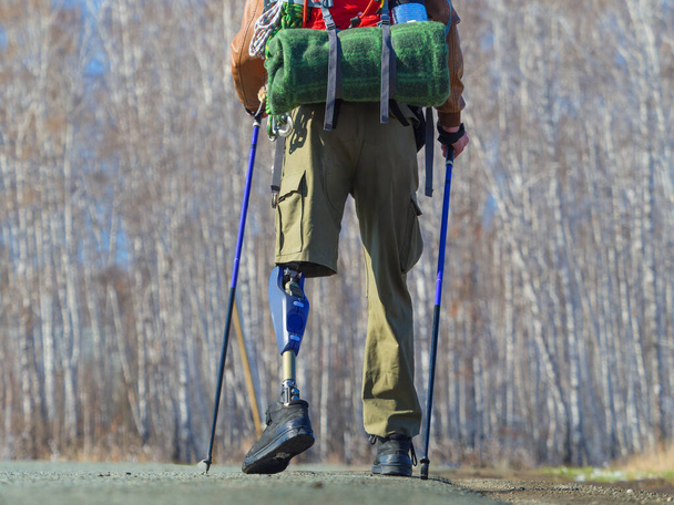 Vista posterior de un hombre con prótesis que intenta caminar nórdico deporte
. - Foto, Imagen