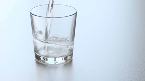 A vizet egy pohárba öntik, és egy pezsgő aszpirin tabletta beleesik a vízbe. - Felvétel, videó