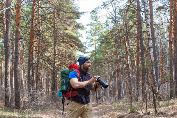 Bird watcher walks through the woods with a camera. - Foto, imagen