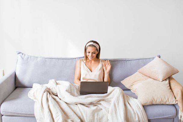 Vrouw thuis met videogesprek in laptop. - Foto, afbeelding