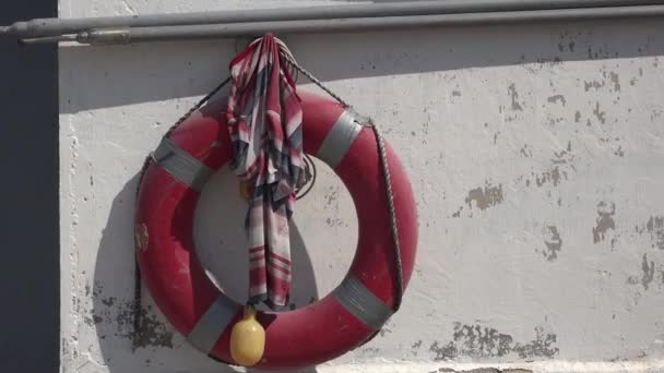 Life buoy hanging on white wall of yacht marina - Footage, Video