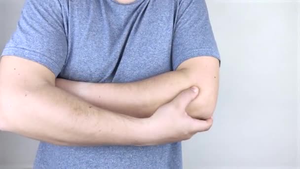 A man suffers from elbow pain. Damaged elbow joint, bone fracture, or sprain. Hand injury and flexion pain concept - Footage, Video