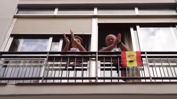 Starší pár tleskání v okně na podporu lidí proti koronaviru - Záběry, video