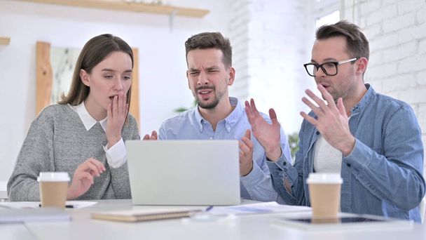 Casual gente de negocios reaccionando al fracaso en el ordenador portátil en la oficina
 - Foto, imagen