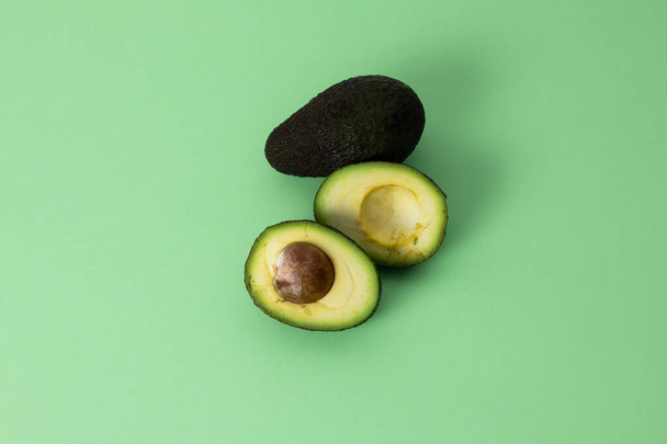 Taze avokadolar ikiye bölünmüş. Moda minimalizmi tarzı fotoğraf - Fotoğraf, Görsel