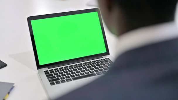 Afrikaanse zakenman op zoek naar laptop met Chroma Key Screen - Foto, afbeelding