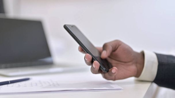Close up of Hands of African Man Using Smartphone in Office - Valokuva, kuva