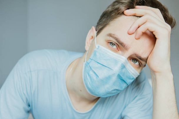Young male mask in quarantined house due to coronavirus pandemic - Valokuva, kuva