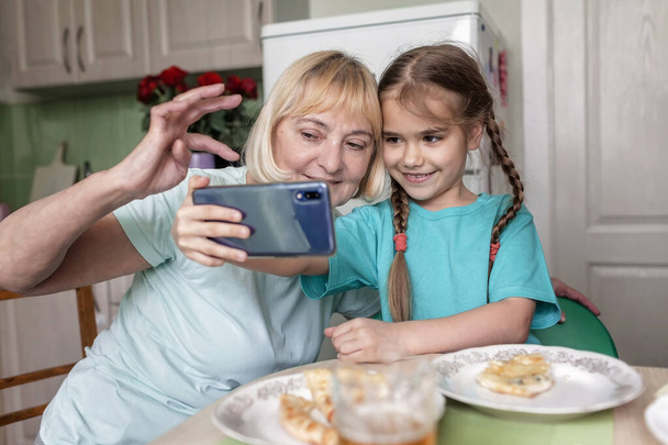 Šťastné vnouče učí svou babičku používat portativní tablet a dělat selfie, online život, nový normální po pandemii koronaviru, šťastný stříbrný surfař digitální rodilou generaci - Fotografie, Obrázek