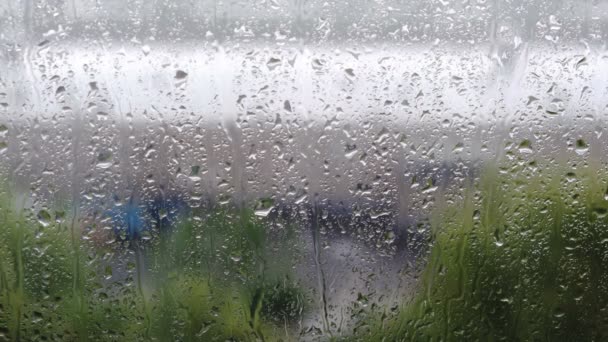 Yağmur damlaları ve şehir manzaralı video klip penceresi. Yağmurlu, yağmurlu, bulutlu bir gün. Video arkaplanı bulanık. - Video, Çekim