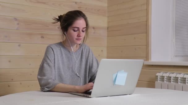 A young businesswoman works from home during quarantine, writes a letter to colleagues in a working chat  - Video, Çekim
