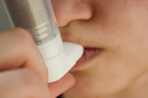 Día Mundial del Asma Mayo 5.inhalador anti-asma en un fondo azul.teenager utiliza un inhalador
. - Foto, imagen