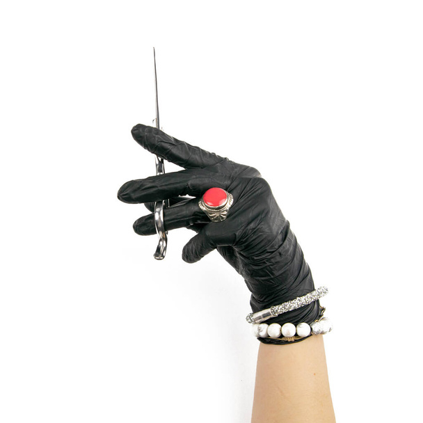 Ruka v rukavici drží stříbrné nůžky na izolovaném bílém pozadí. - Fotografie, Obrázek