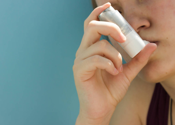 Journée mondiale de l'asthme 5 mai inhalateur anti-asthme sur fond bleu.adolescent utilise un inhalateur
. - Photo, image