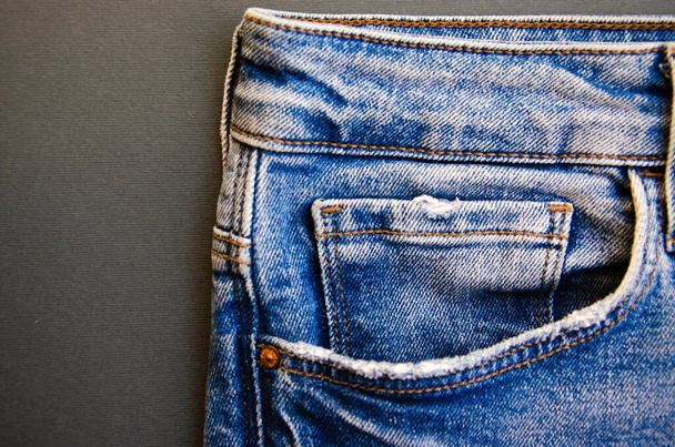 Jeans su sfondo nero. Elementi di jeans, tasche, cuciture in primo piano. Jeans strappati. Copia spazio
 - Foto, immagini