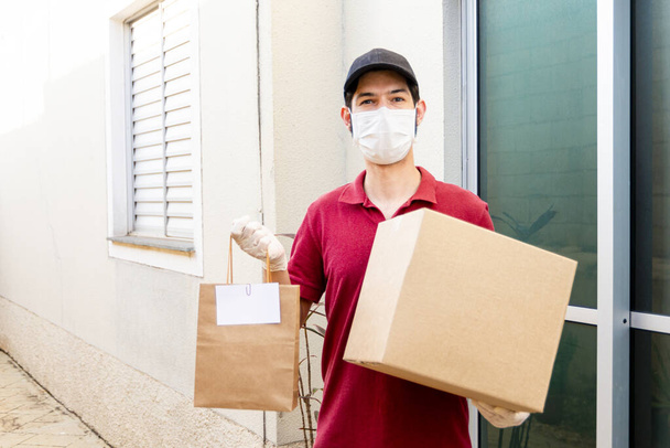 Latin man with items for delivery. Home delivery food during virus outbreak, coronavirus panic and pandemics. Stay safe. - Photo, Image