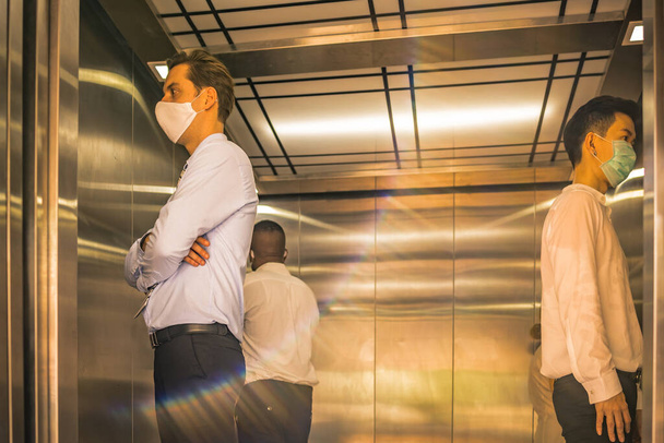 Соціальна дистанція на ліфті з 4 пасажирами стоїть в кутку від спалаху коронавірусної ковірусної ситуації19. Концепція усвідомлення безпечного та низького ризику
. - Фото, зображення