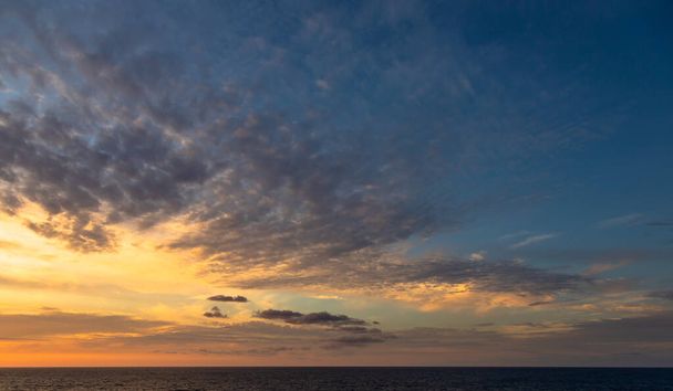 Napnyugta és a Karib-tenger trópusi vizein sodródó drámai felhők világítanak a napfény utolsó pillanatai által.. - Fotó, kép